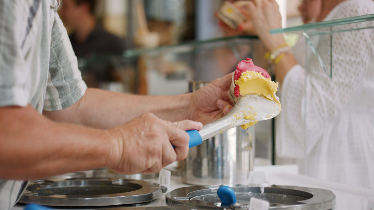 Eissorten werden in den Becher gespachtelt
