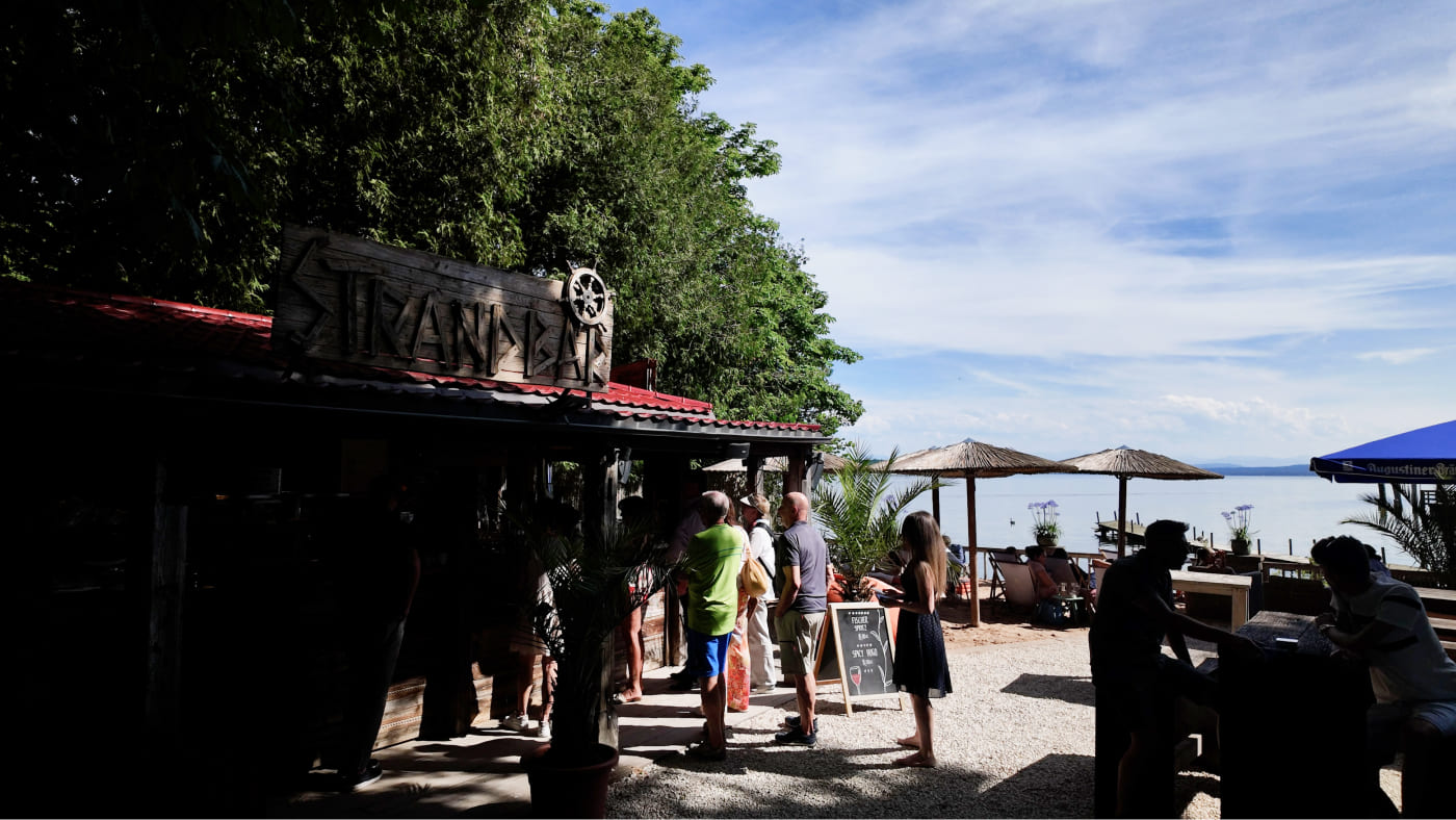 Besucher stehen an der Fischer Strandbar an